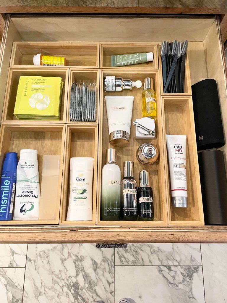 Bathroom cabinet organized into zones with contained products