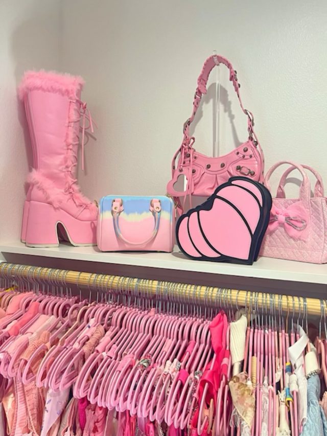 Pink platform boots and quilted handbags shelved above a row of hanging pink garments