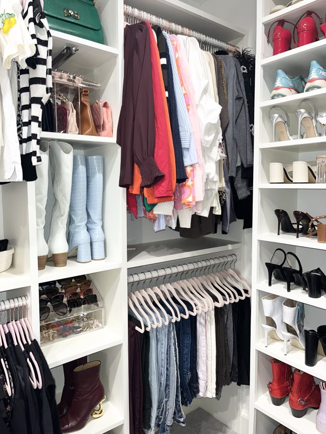 A walk-in closet with hanging sections either side and shoes shelved in a tower