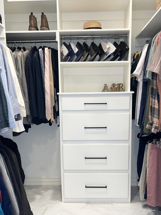A his-and-hers closet with a monogrammed drawer tower between two hanging sides