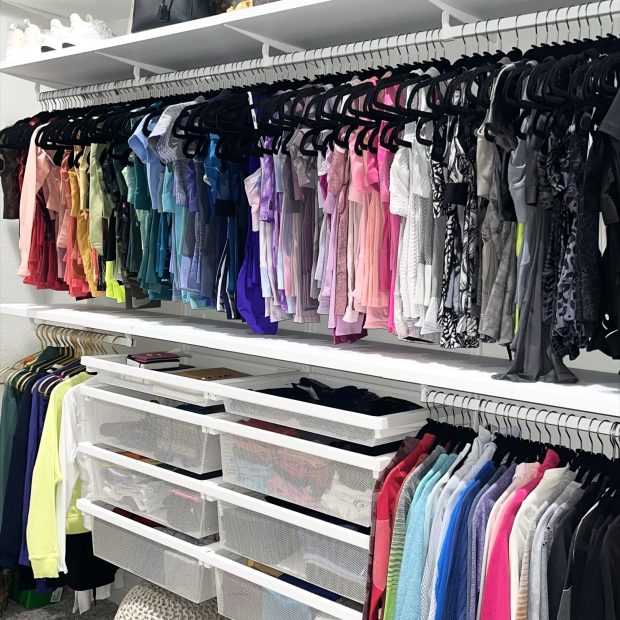 Activewear hung by color above clear drawers and a woven floor pouf