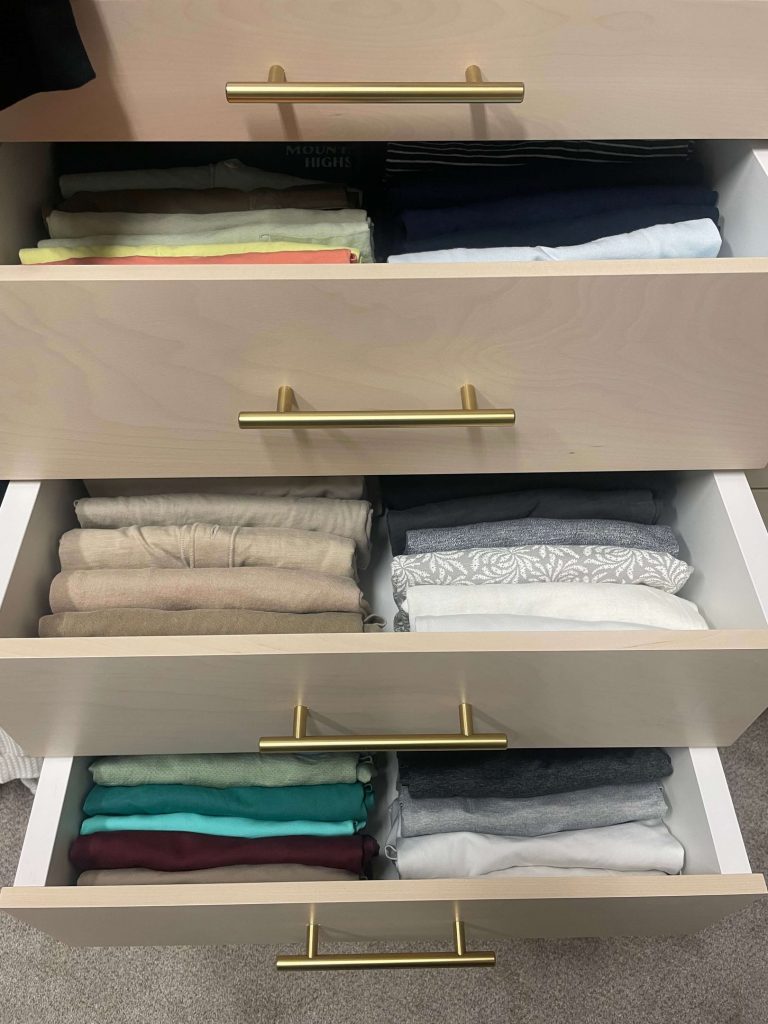 Closet drawer with precisely folded clothing separated into compartments