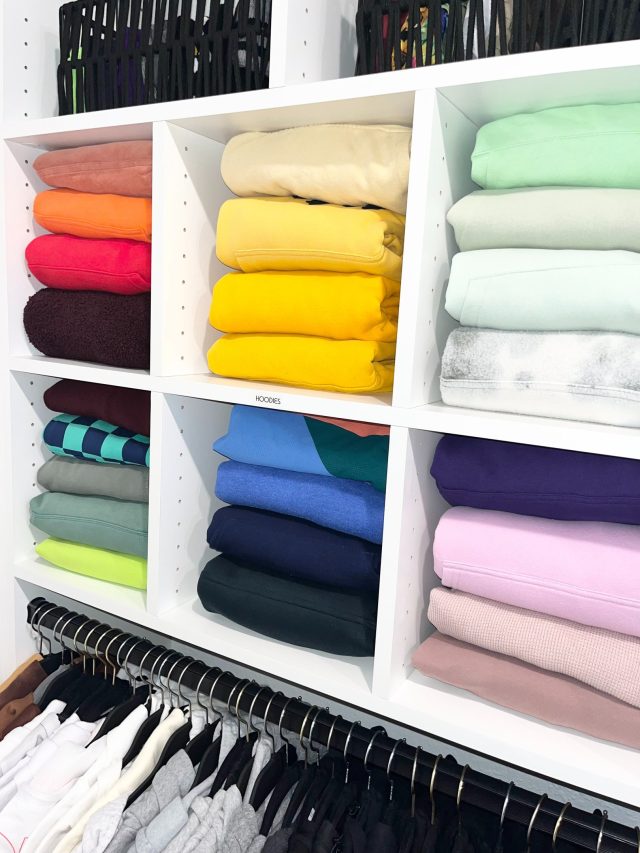 Folded clothing placed into a primary closet during a full home unpack