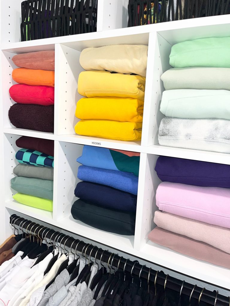Primary closet with folded clothing arranged by category
