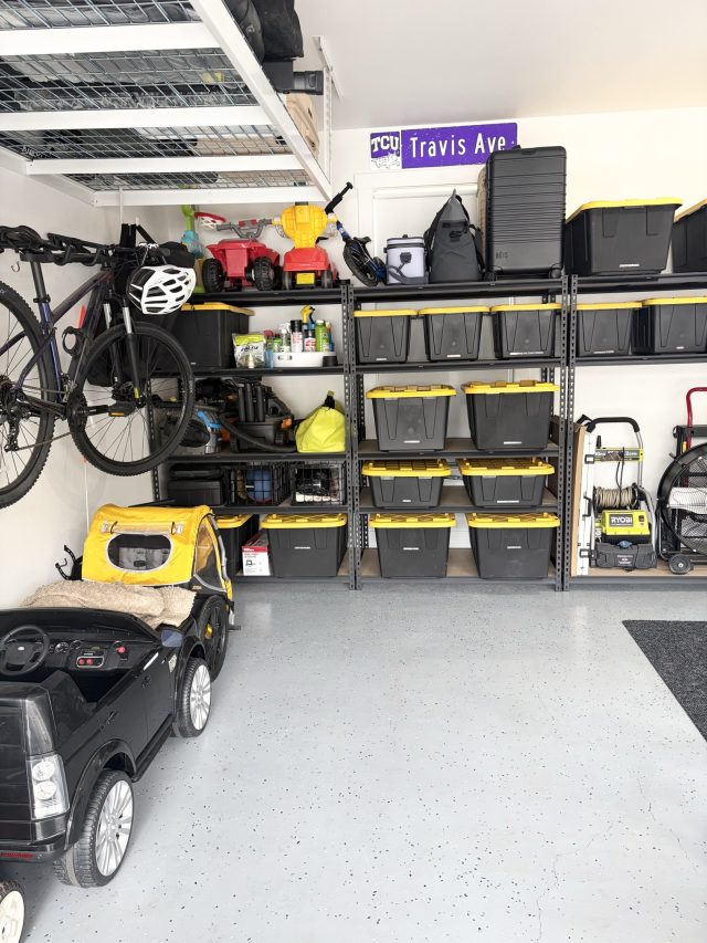 A finished garage with wall shelving, labeled bins and bikes stored overhead