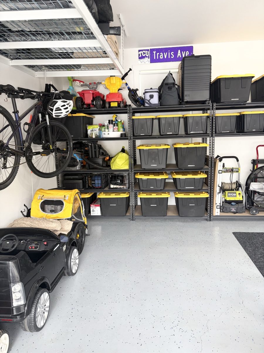 A finished garage with wall shelving, labeled bins and bikes stored overhead