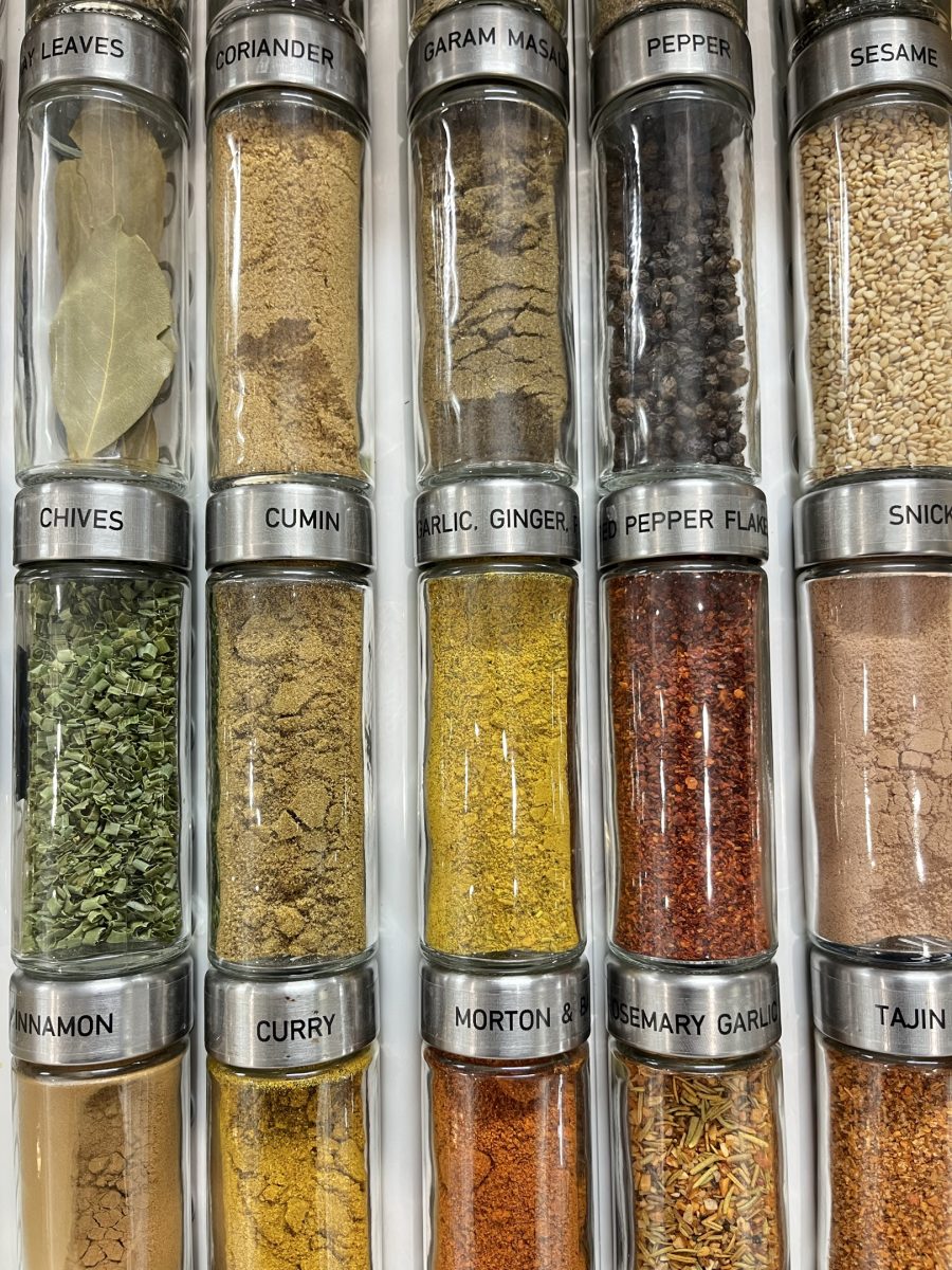 Tall glass spice jars labeled on the cap and stored on their sides