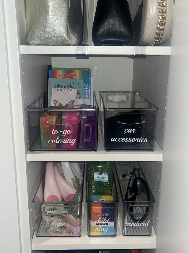 A hall closet with handbags above and clear bins for coloring kits and car accessories